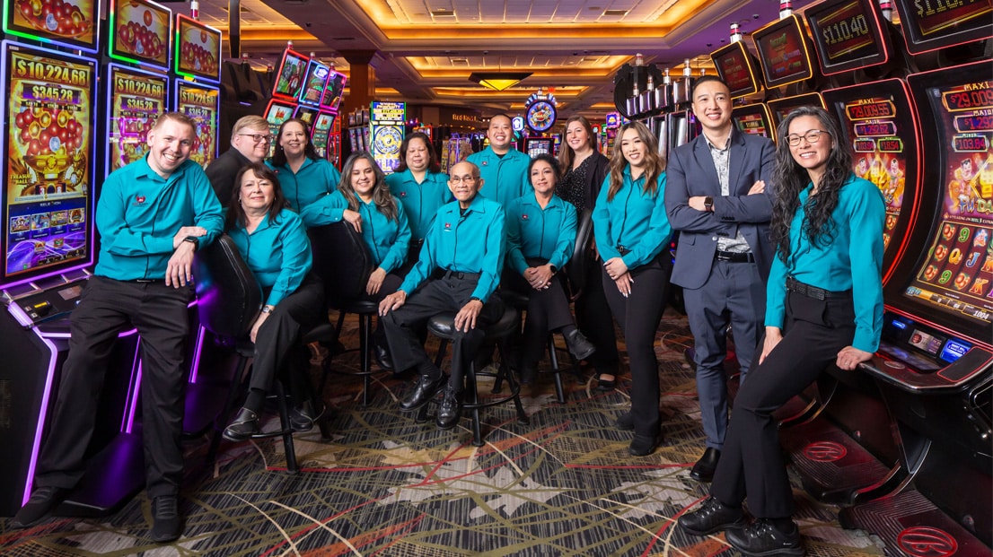Casino staff staged photo with slot machines in background