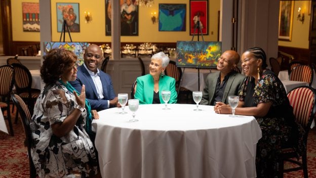 Disney Imagineers gather around a table to discuss the new attraction inspired by Princess and the Frog.