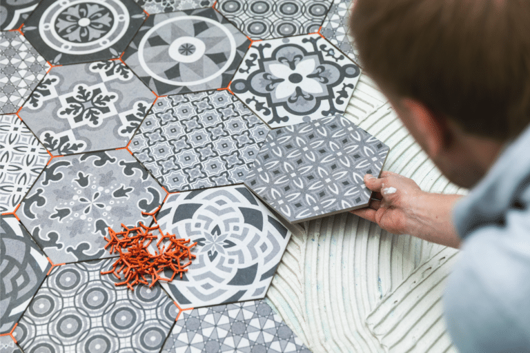 person laying decorative tiles down