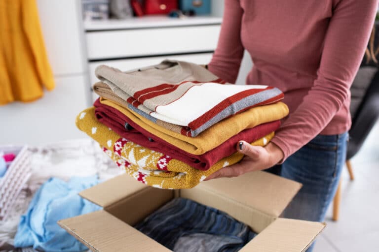 Woman putting her clothes in a delivery box stock photo