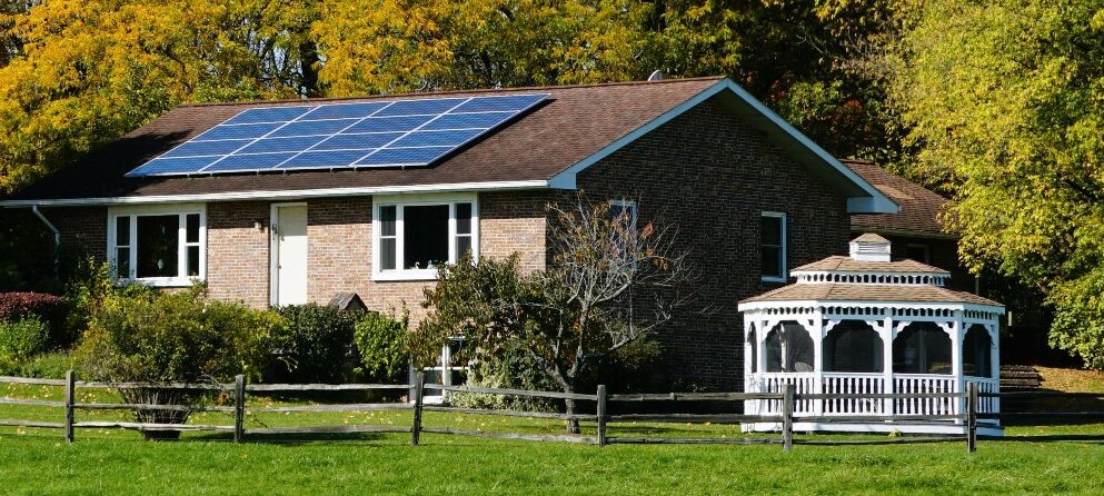 A house with a solar system surrounded by beautiful fall foliage near Upstate New York, U.S.A