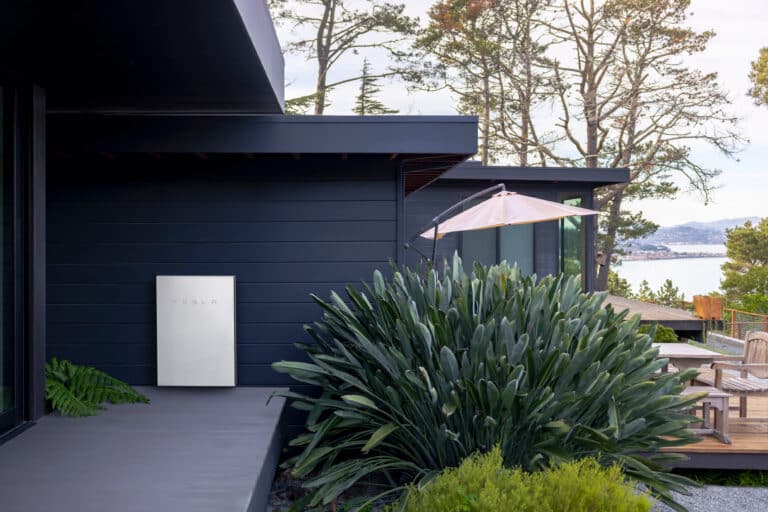 tesla powerwall battery on the exterior wall of a modern home