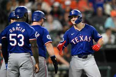 Texas Rangers' Wyatt Langford, right, celebrates his three-run home run with Adolis García...