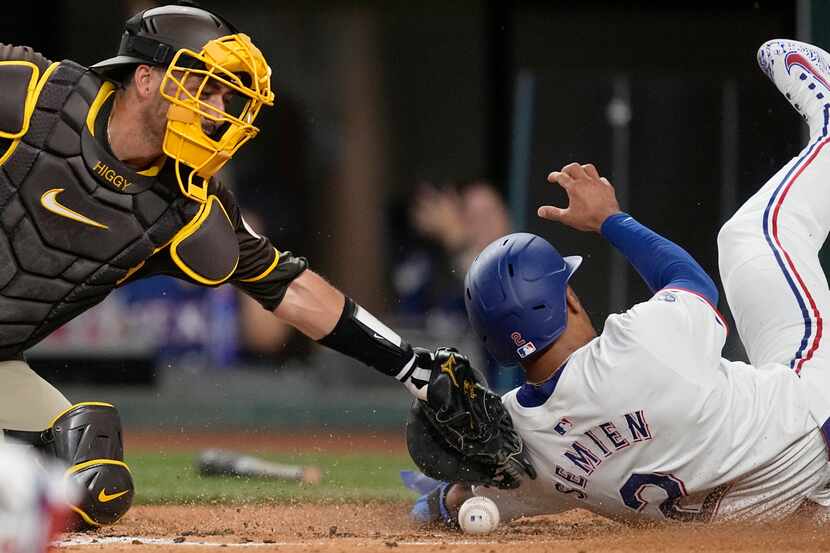 San Diego Padres catcher Kyle Higashioka loses the ball as he applies the tag on Texas...