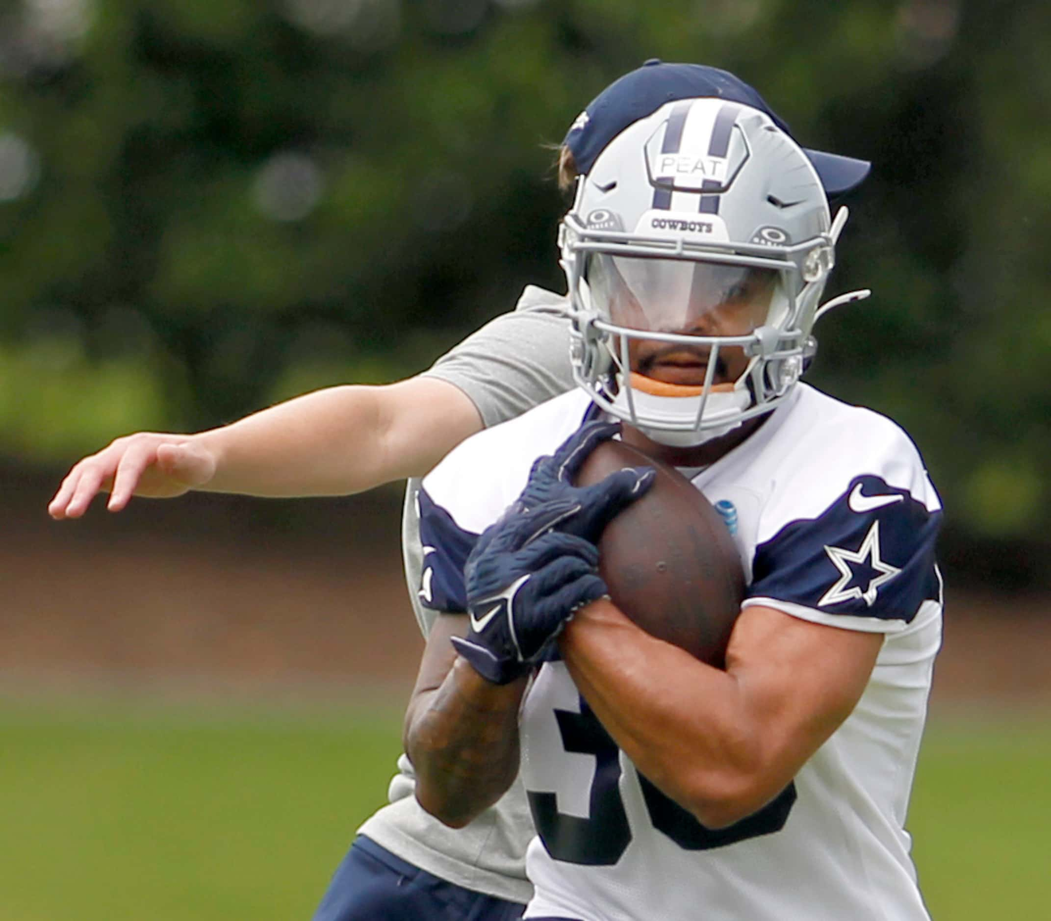 Dallas Cowboys running back Nathaniel Peat (36) protects the ball during a running drill....