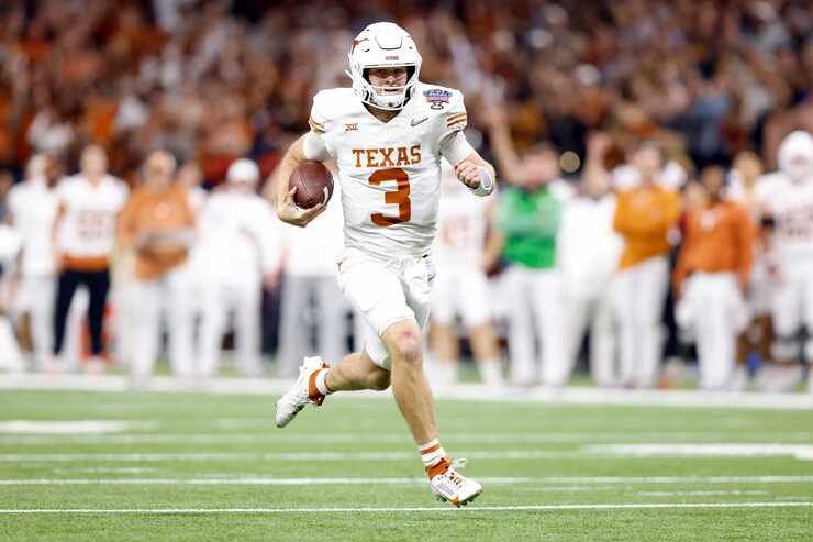 Texas Longhorns quarterback Quinn Ewers (3) keeps the ball and races toward the goal line...