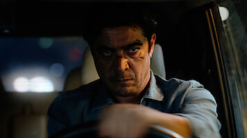 Riccardo Scamarcio as Pietro drives a car at night with a cut on his face and an angry expression in 'Vanished into the Night'