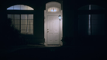 An exterior of a door at night.