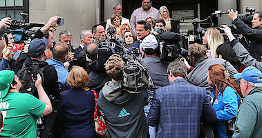 The media crowds Karen Reade as she exits the courthouse.