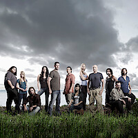 The cast of 'Lost' standing in a field with ominous clouds behind them.
