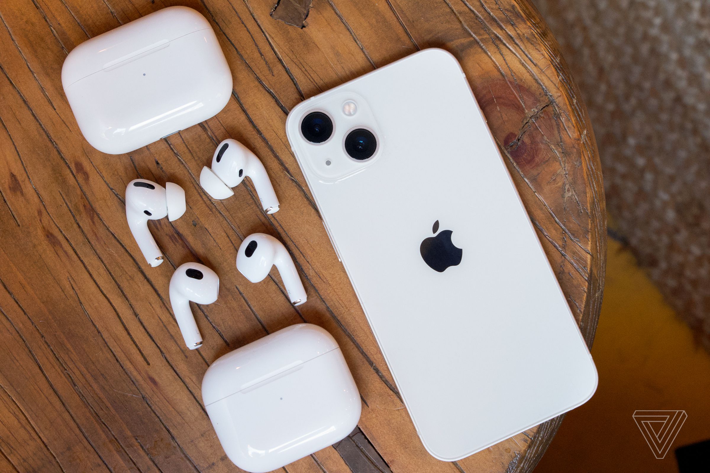 AirPods Pro, AirPods, and an iPhone on a table.