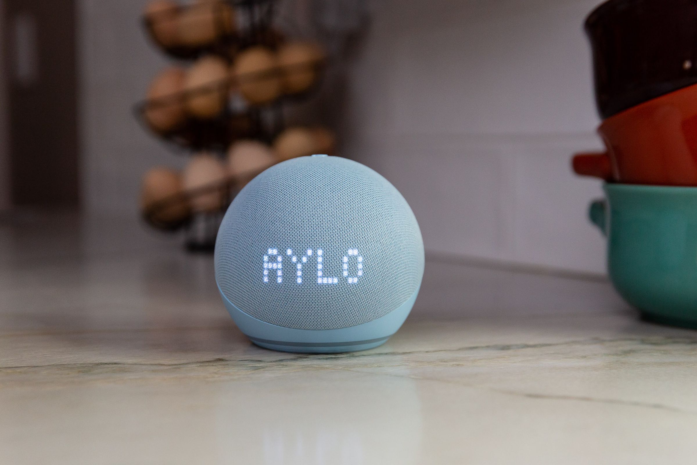 An Echo Dot on a counter displaying the letters AYLO, as in TAYLOR SWIFT