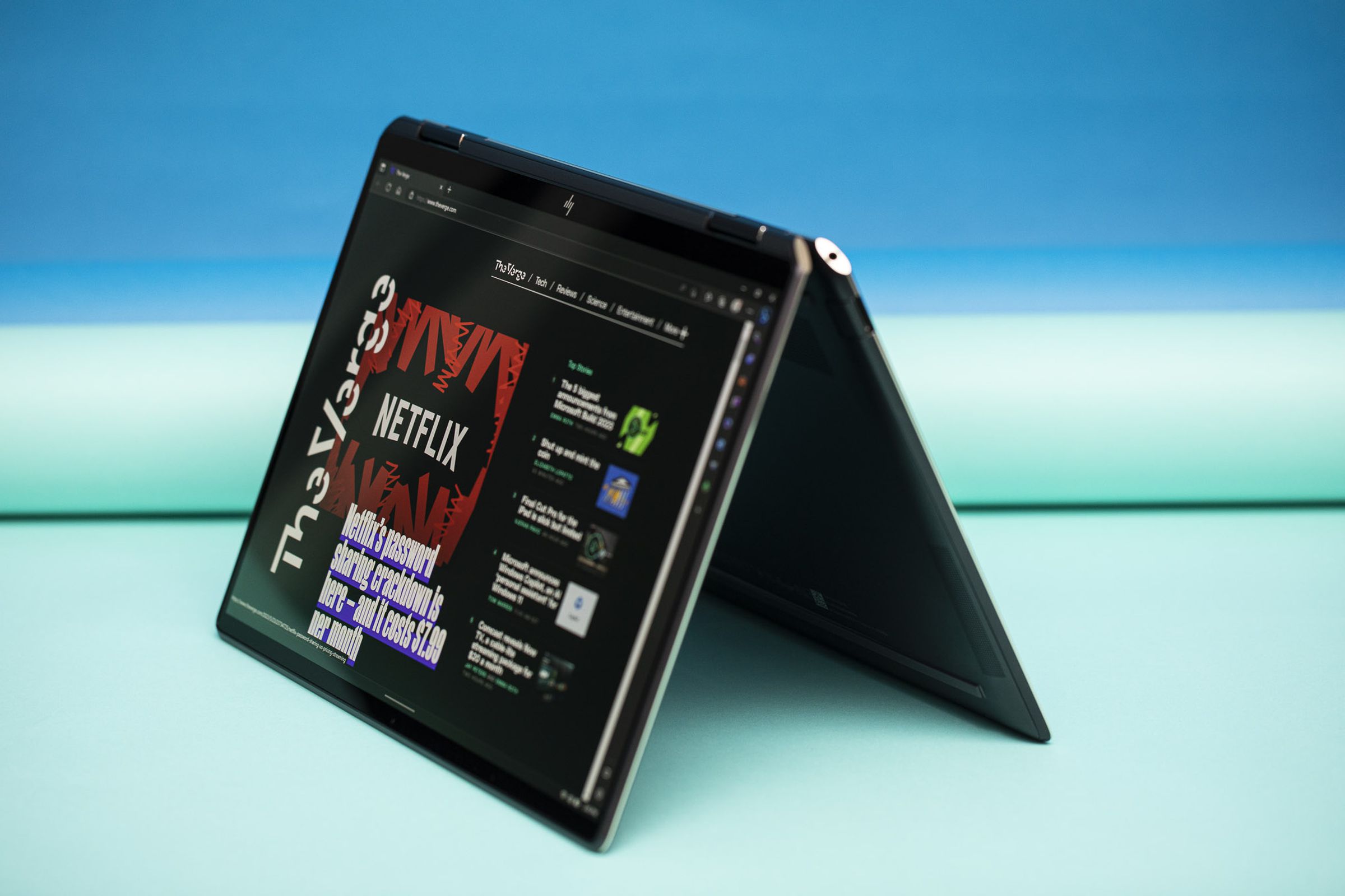 The HP Spectre x360 13.5 in tent mode displaying The Verge homepage.