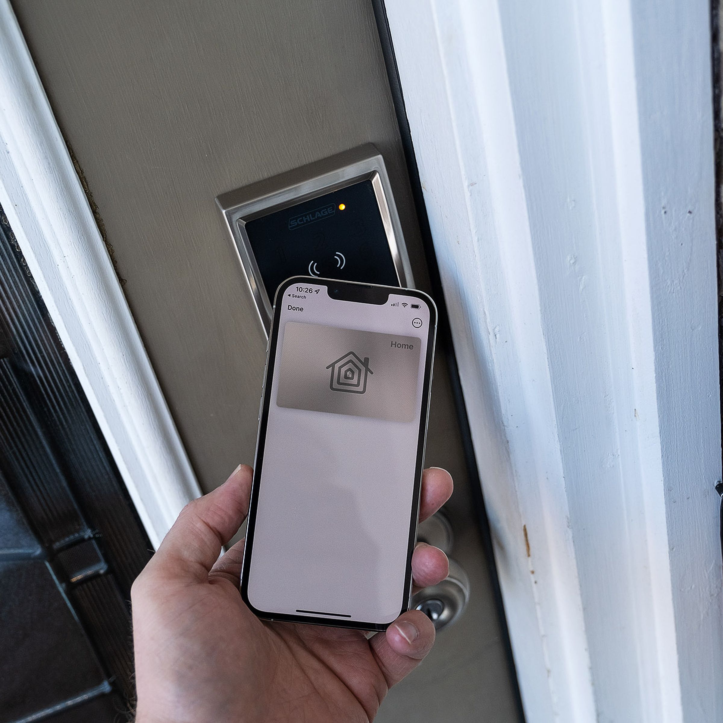 An iPhone being used to unlock the Schlage Encode Plus smart lock.