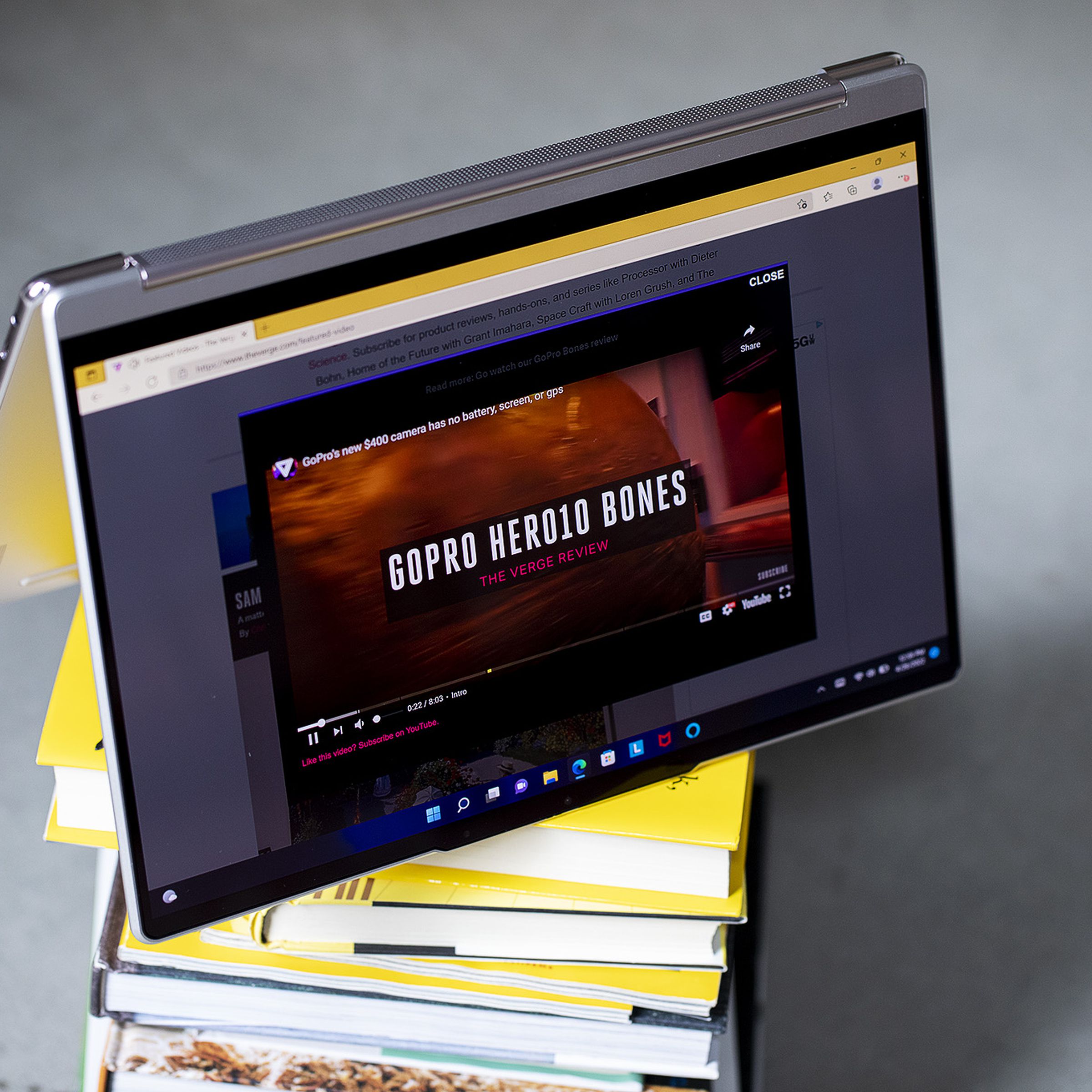 The Lenovo Yoga 9i in tent mode atop a stack of books.