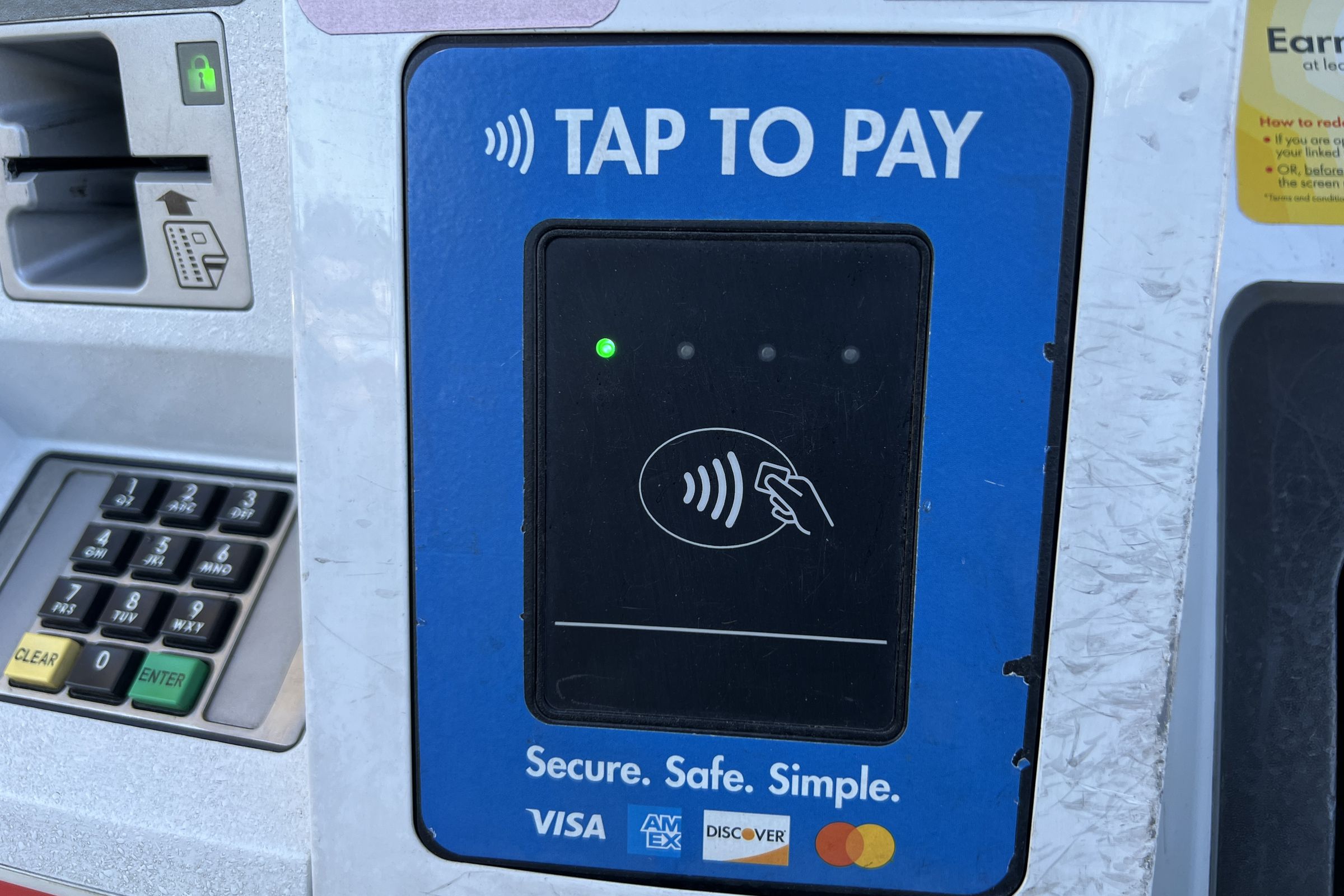 Credit card reader with a message stating Tap to Pay and logos for various payment cards on a gas pump in Lafayette, California, May 9th, 2024.