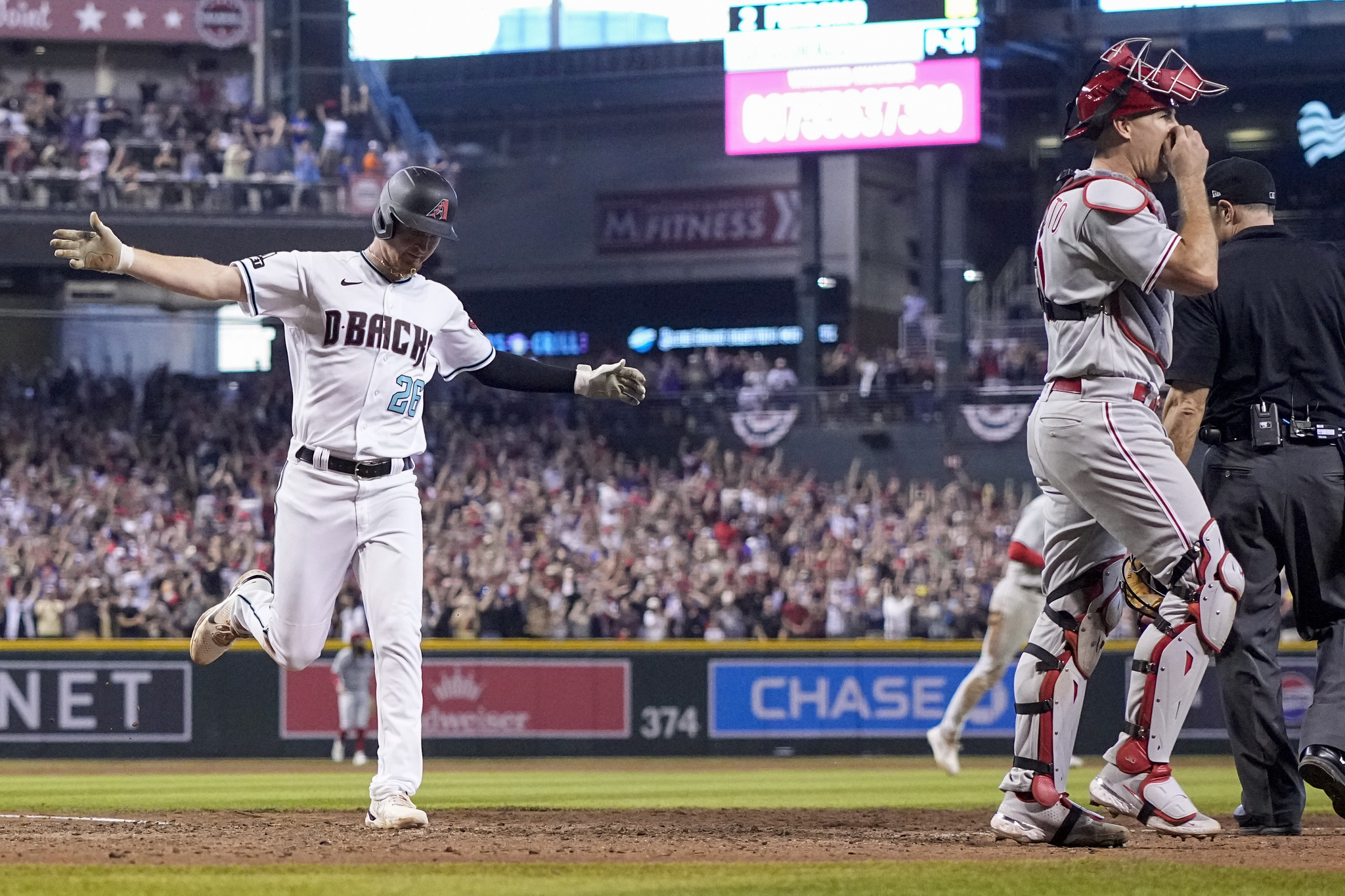 Arizona Diamondbacks Pavin Smith celebrates after scoring the game winning run past Philadelphia Phillies catcher J.T. Realmuto.