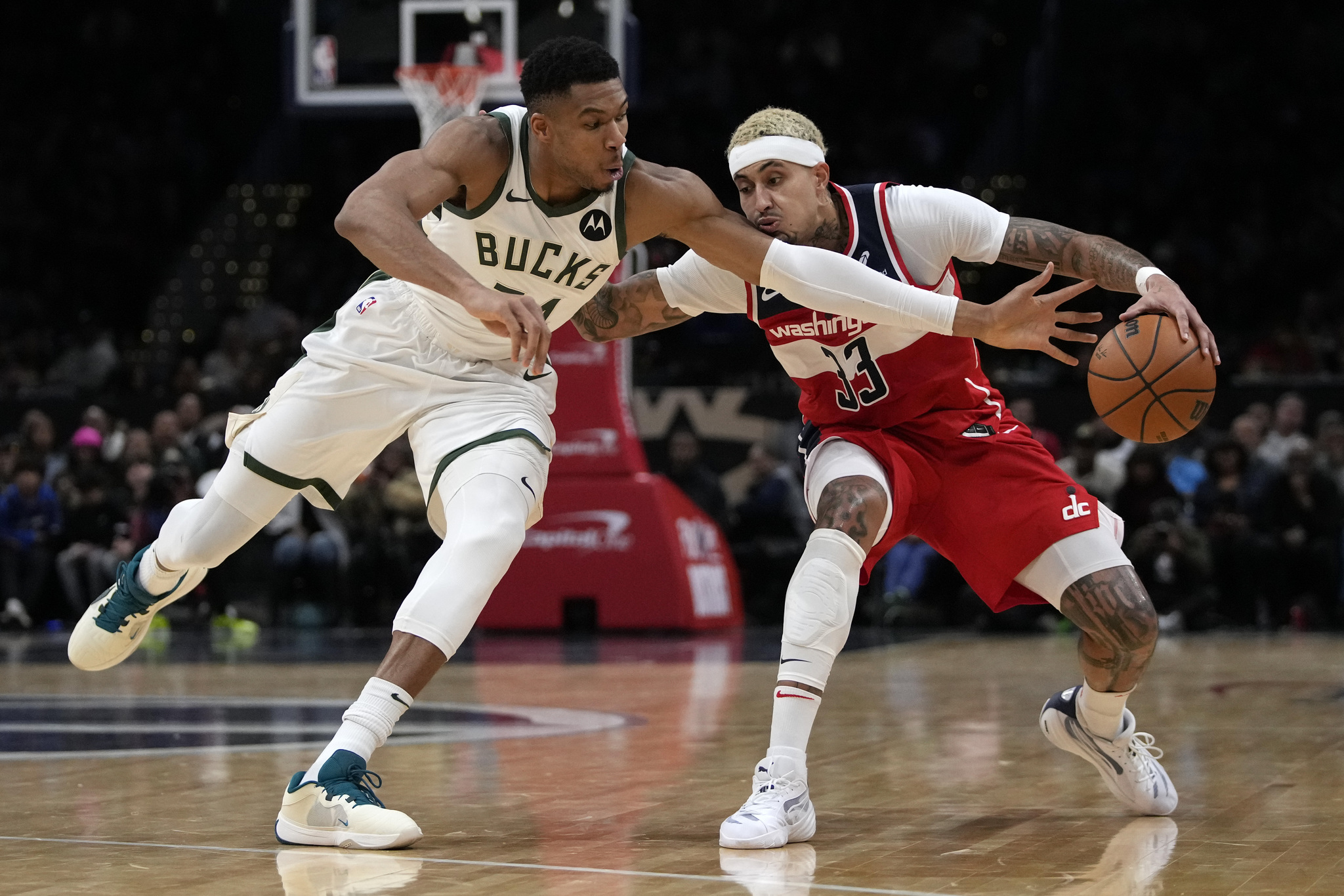 Milwaukee Bucks forward Giannis Antetokounmpo reaches to knock the ball away from Washington Wizards forward Kyle Kuzma