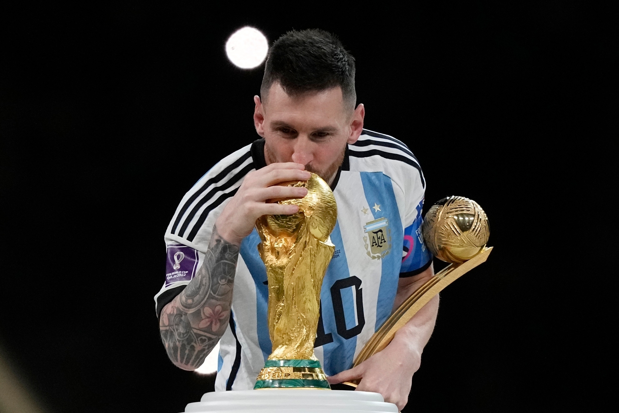 Lionel Messi kisses the World Cup trophy