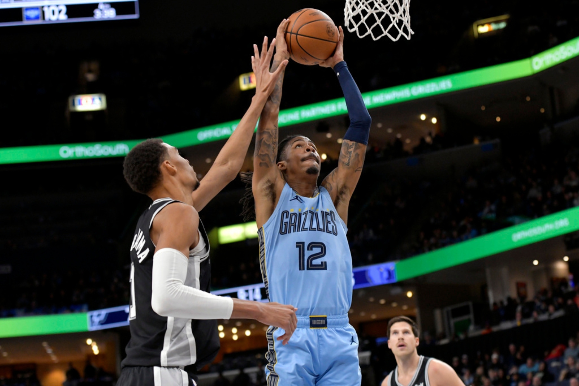 Memphis Grizzlies guard Ja Morant (12) shoots against San Antonio Spurs center Victor Wembanyama (1) in the second half of an NBA basketball game Tuesday, Jan. 2, 2024, in Memphis, Tenn. (AP Photo/Brandon Dill)