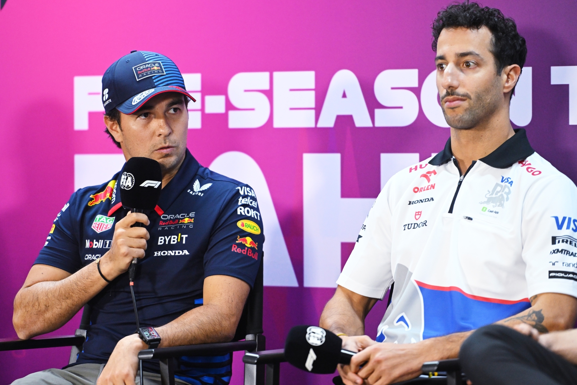 Checo P�rez speaks at a press conference with Ricciardo beside him