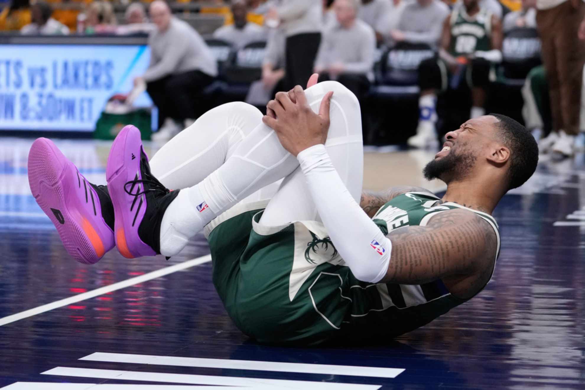 Damian Lillard grabs his leg after being injured during the first half in Game 2 against the Indiana Pacers