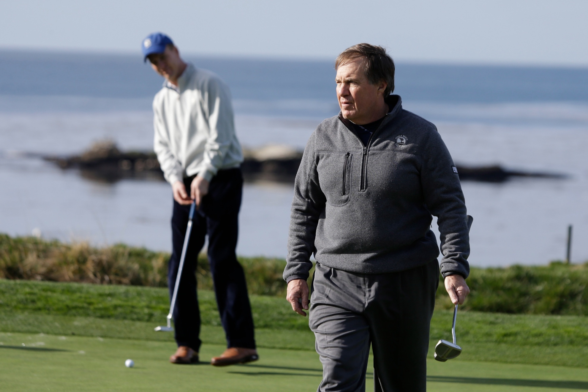 New England Patriots head coach Bill Belichick, right, and Denver Broncos quarterback Peyton Manning, left, look over the fourth green of the Pebble Beach Golf Links during a practice round at the AT&T Pebble Beach Pro-Am golf tournament Wednesday, Feb. 5, 2014, in Pebble Beach, Calif. (AP Photo/Eric Risberg)