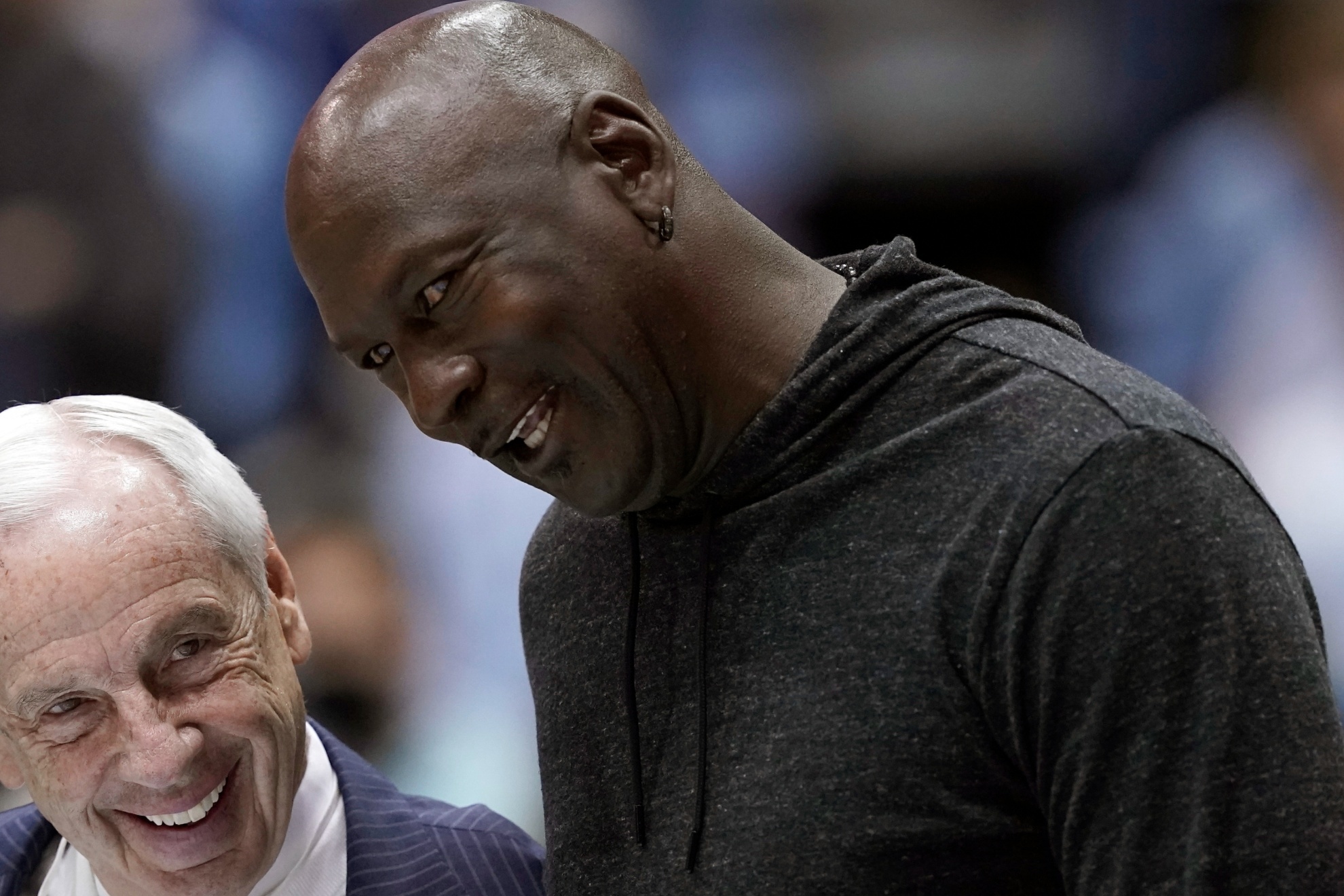 Retired North Carolina coach Roy Williams, left, and former player Michael Jordan speak while being recognized with the 1982 team during a break in the second half of an NCAA college basketball game between North Carolina and North Carolina State in Chapel Hill, N.C., Saturday, Jan. 29, 2022. (AP Photo/Gerry Broome)