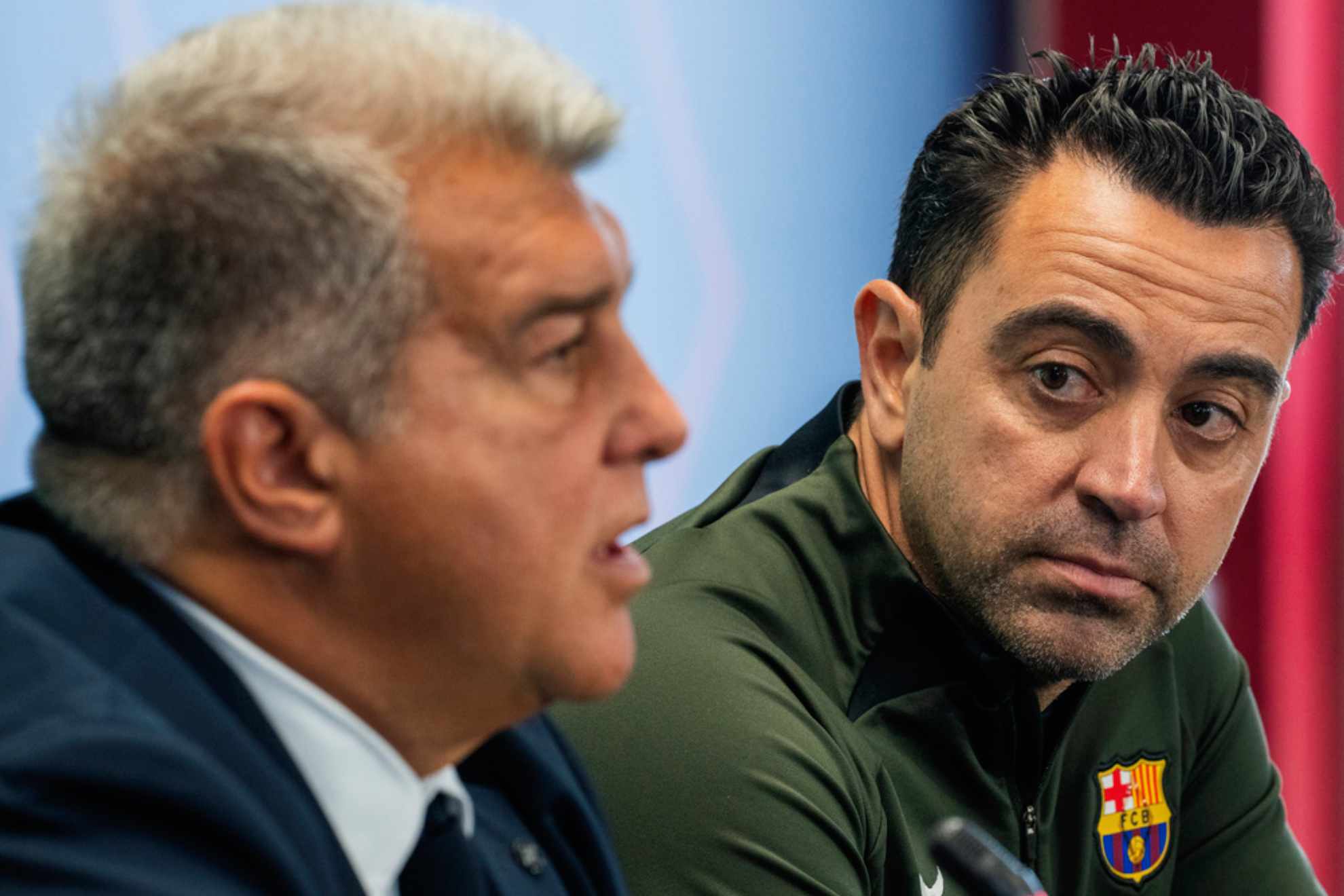 Xavi Hernandez listens to Barcelonas president Joan Laporta /