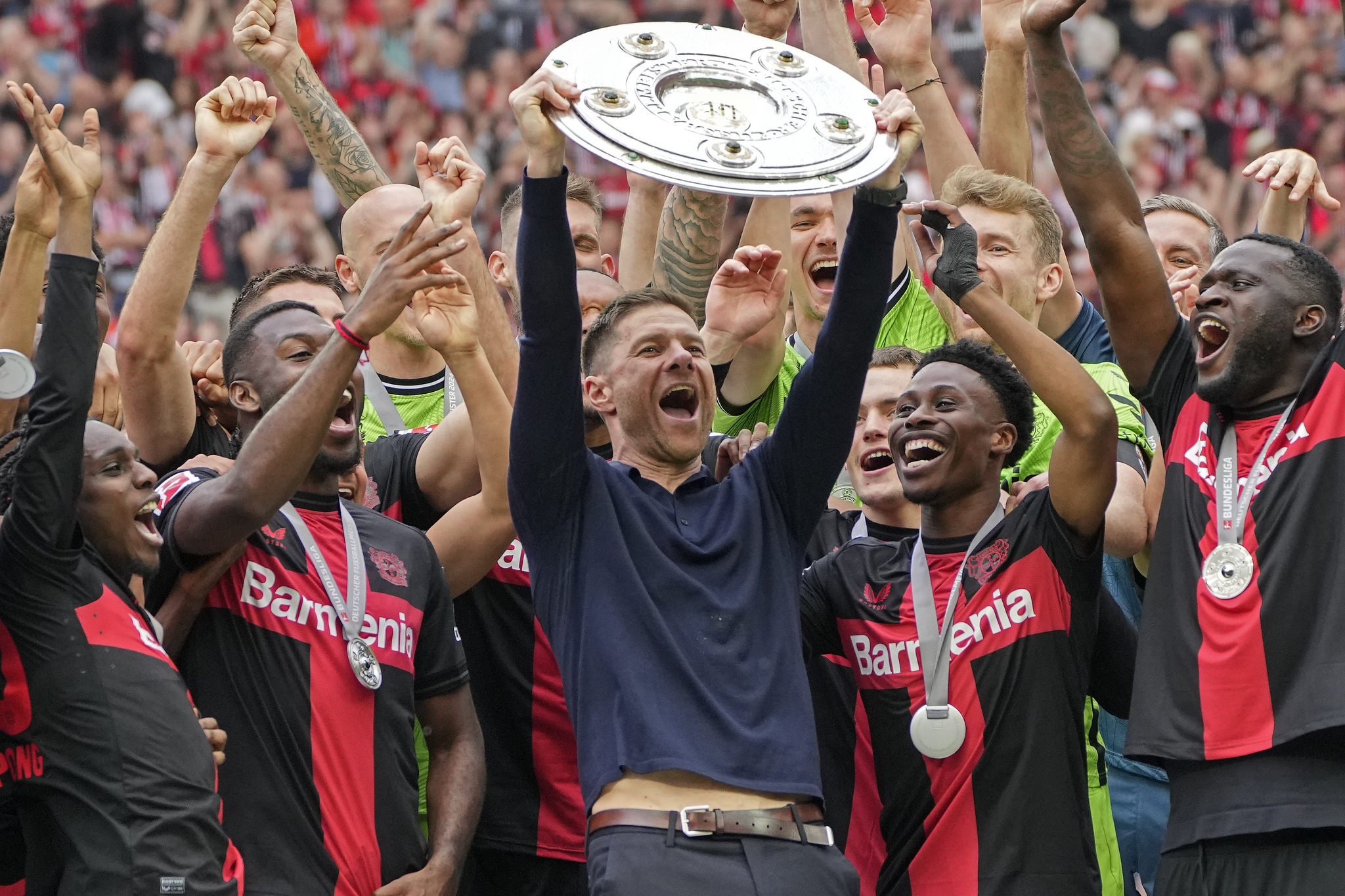 Leverkusen head coach Xabi Alonso celebrates with his team after winning the Bundesliga