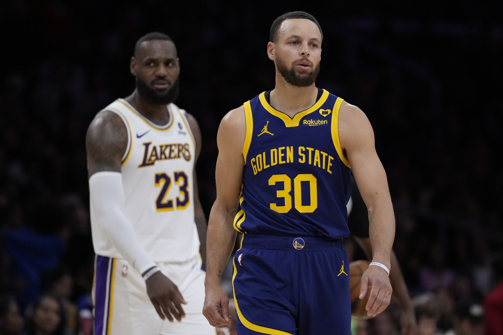 Golden State Warriors guard Stephen Curry (30) and Los Angeles Lakers forward LeBron James (23) react after play was stopped