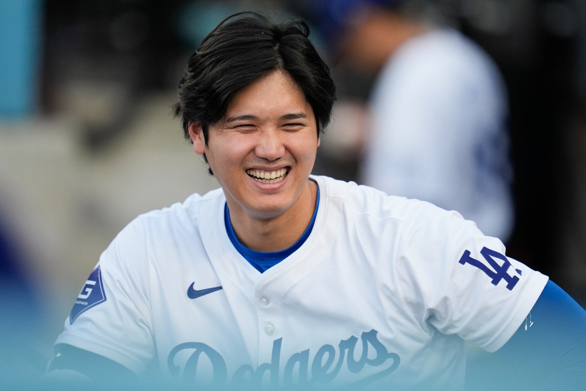 Los Angeles Dodgers Shohei Ohtani smiles in the dugout before the teams baseball game against the Arizona Diamondbacks, Tuesday, May 21, 2024, in Los Angeles. (AP Photo/Marcio Jose Sanchez)