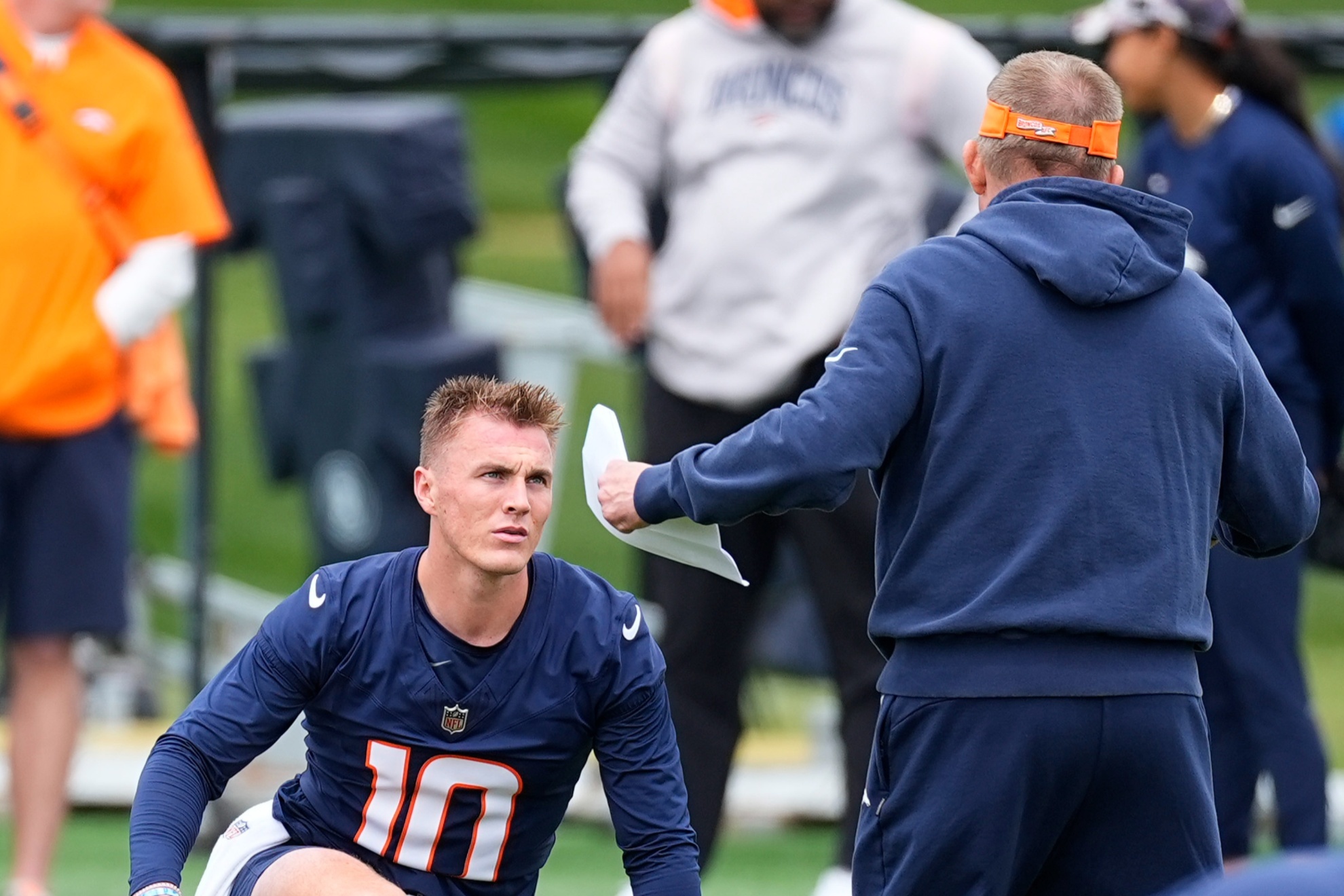 Denver Broncos quarterback Bo Nix, center left, confers with head coach Sean Payton, center right, during an NFL football rookie minicamp practice Saturday, May 11, 2024, in Centennial, Colo. (AP Photo/David Zalubowski)