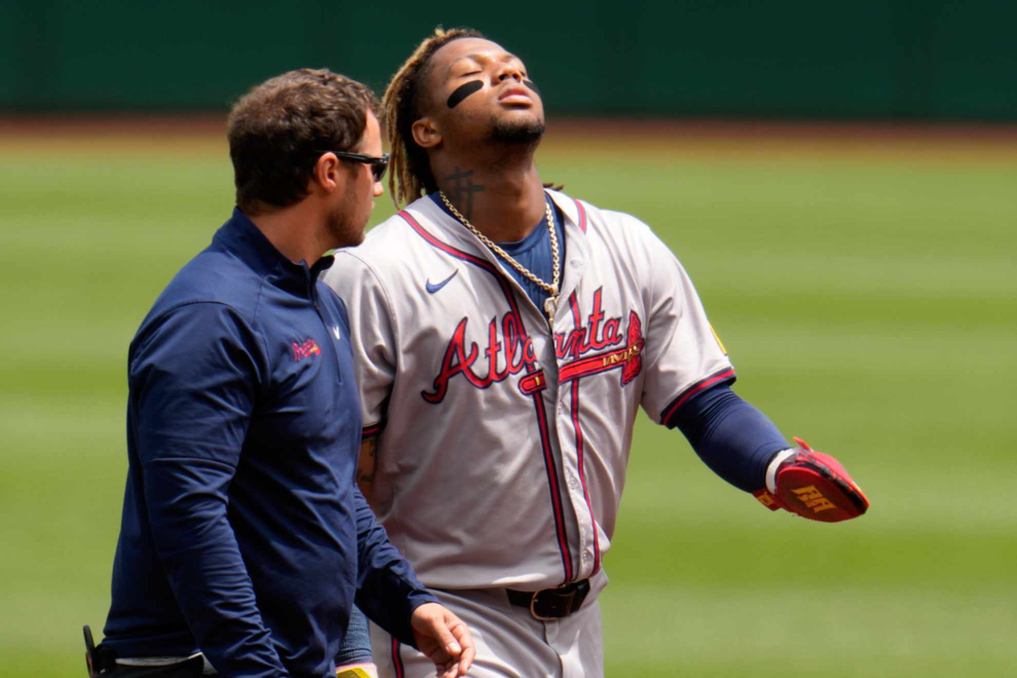 Atlanta Braves Ronald Acu�a Jr., right, walks off the field with a trainer after being injured /