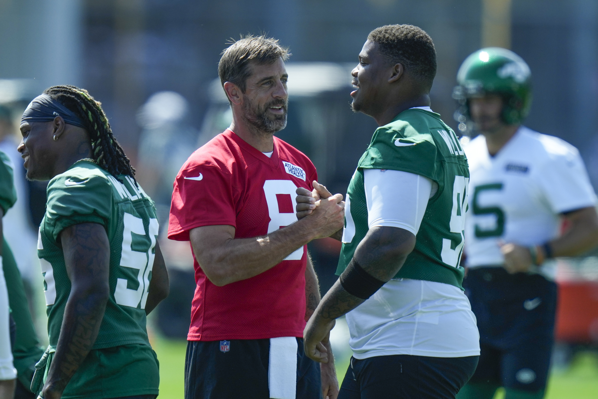 Quarterback Aaron Rodgers (8) greets defensive line Quinnen Williams (95)