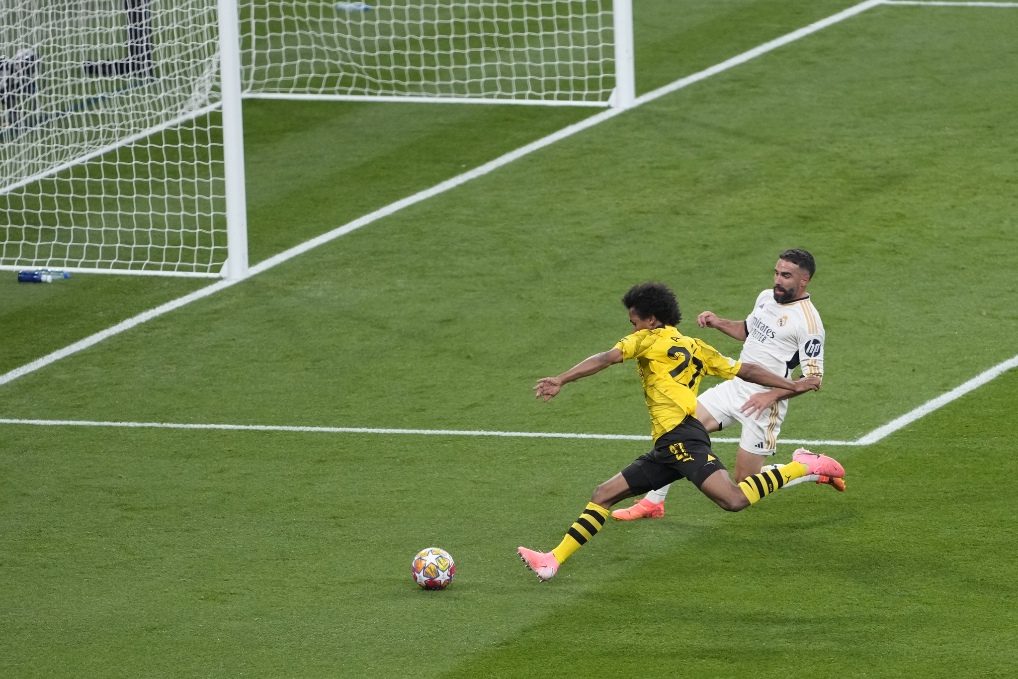 Dortmund's Karim Adeyemi, left, attempts a shot at goal in front of Real Madrid's Dani Carvajal