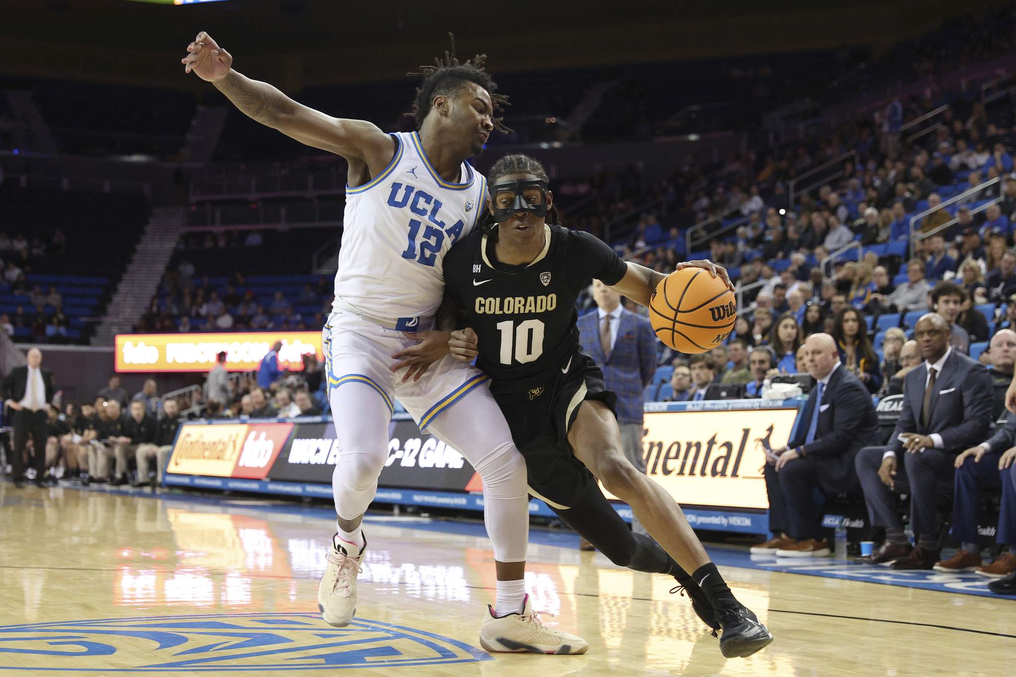 Colorado forward Cody Williams (10) drives to the basket against UCLA guard Sebastian Mack (12) during the first half of an NCAA college basketball game