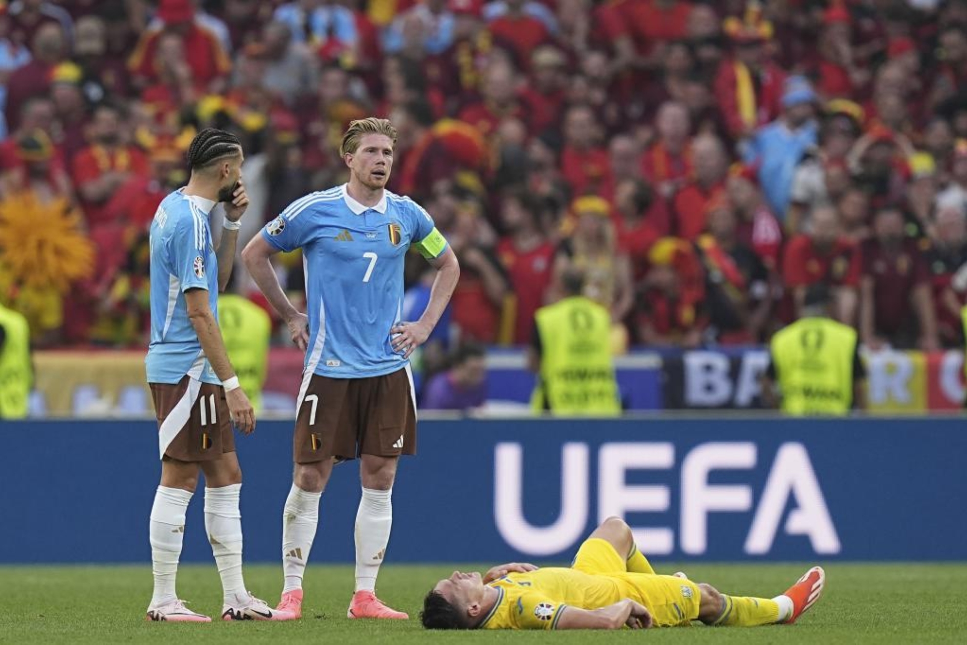 Belgiums Kevin De Bruyne, center, and Yannick Carrasco, left, gather next to Ukraines Oleksandr Tymchyk