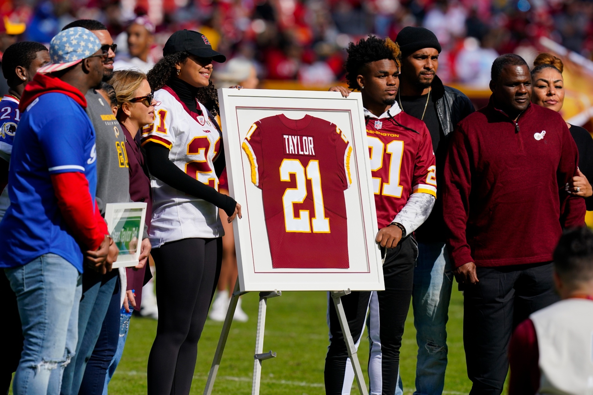 Family members of the late Sean Taylor gather on the field as the Washington Football Team retire his jersey during a halftime ceremony at an NFL football game against the Kansas City Chiefs, Sunday, Oct. 17, 2021, in Landover, Md. (AP Photo/Patrick Semansky)