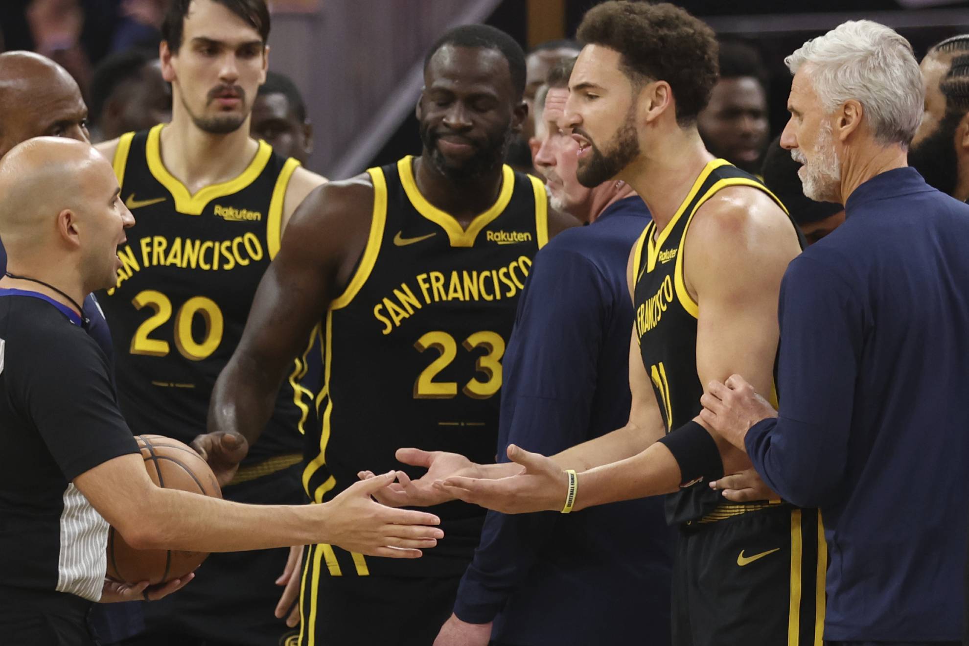 Golden State Warriors guard Klay Thompson, right, and forward Draymond Green, center, argue with a referee after being ejected from the game during the first half of an in-season NBA tournament basketball game against the Minnesota Timberwolves in San Francisco.