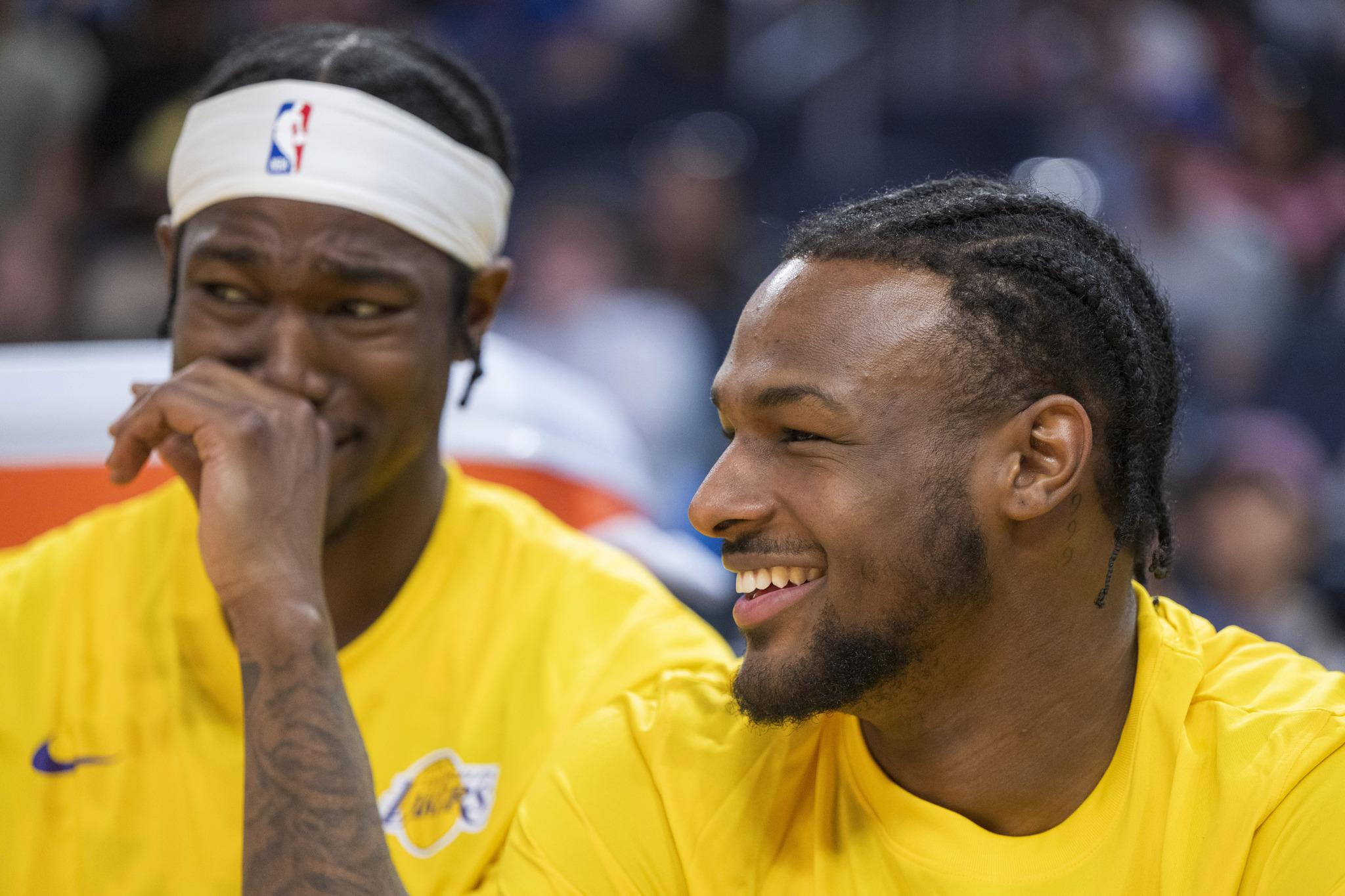 Los Angeles Lakers guard Bronny James, right, laughs with teammates while sitting on the bench