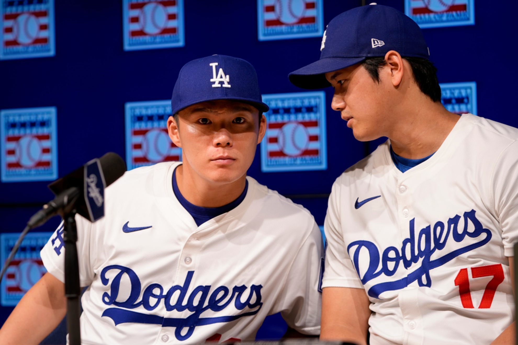 Yoshinobu Yamamoto, left, leans in to speak with designated hitter Shohei Ohtani during a news conference /