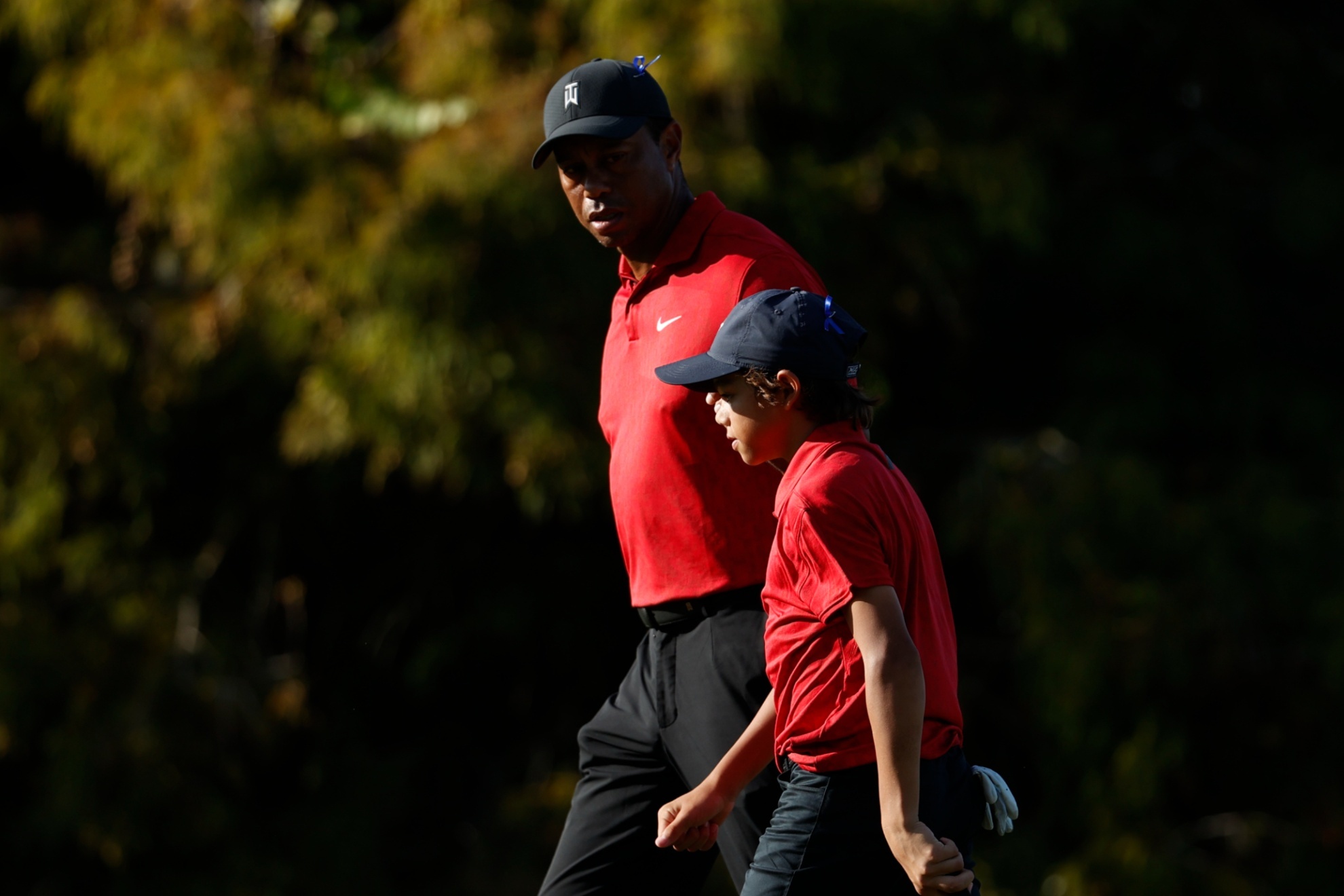 Tiger Woods walks off the 16th hole with son Charlie Woods during the second round of the PNC Championship golf tournament Sunday, Dec. 19, 2021, in Orlando, Fla. (AP Photo/Scott Audette)