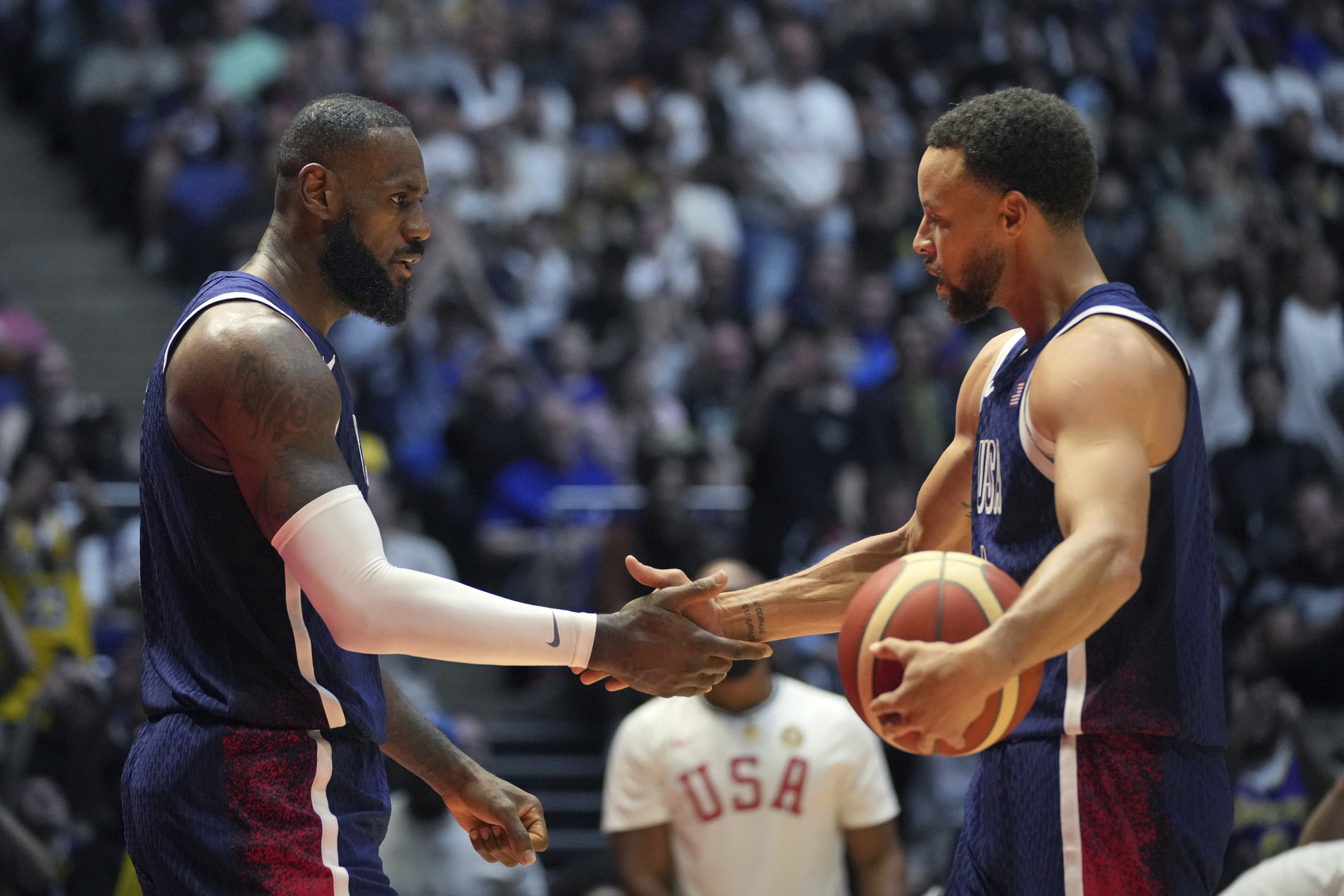 United States forward LeBron James, left and United States guard Stephen Curry shake hands during an exhibition basketball game