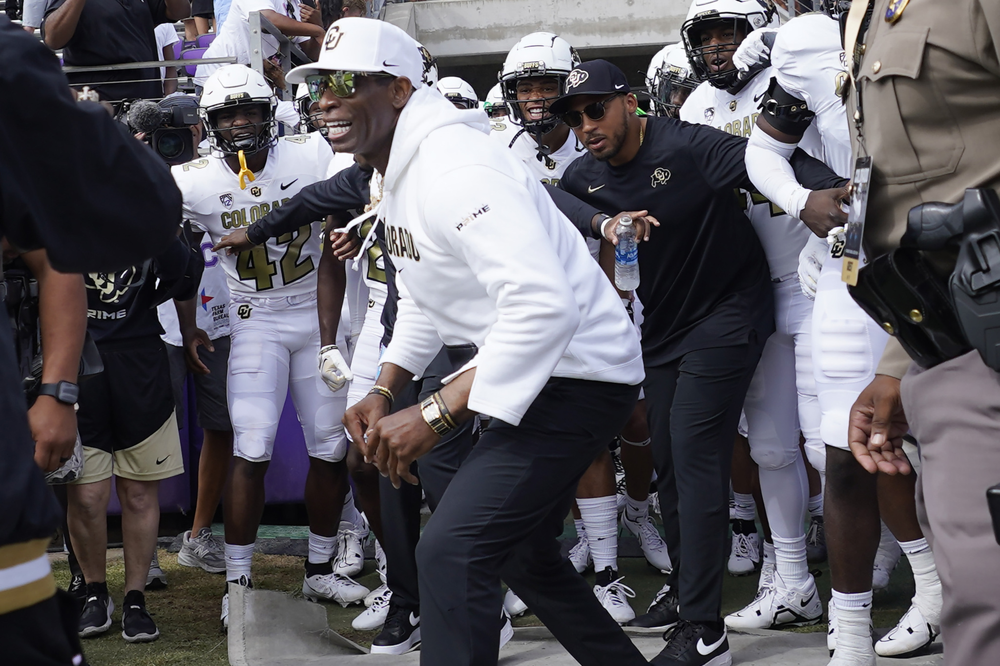 Colorado head coach Deion Sanders runs onto the field with his team for an NCAA college football game