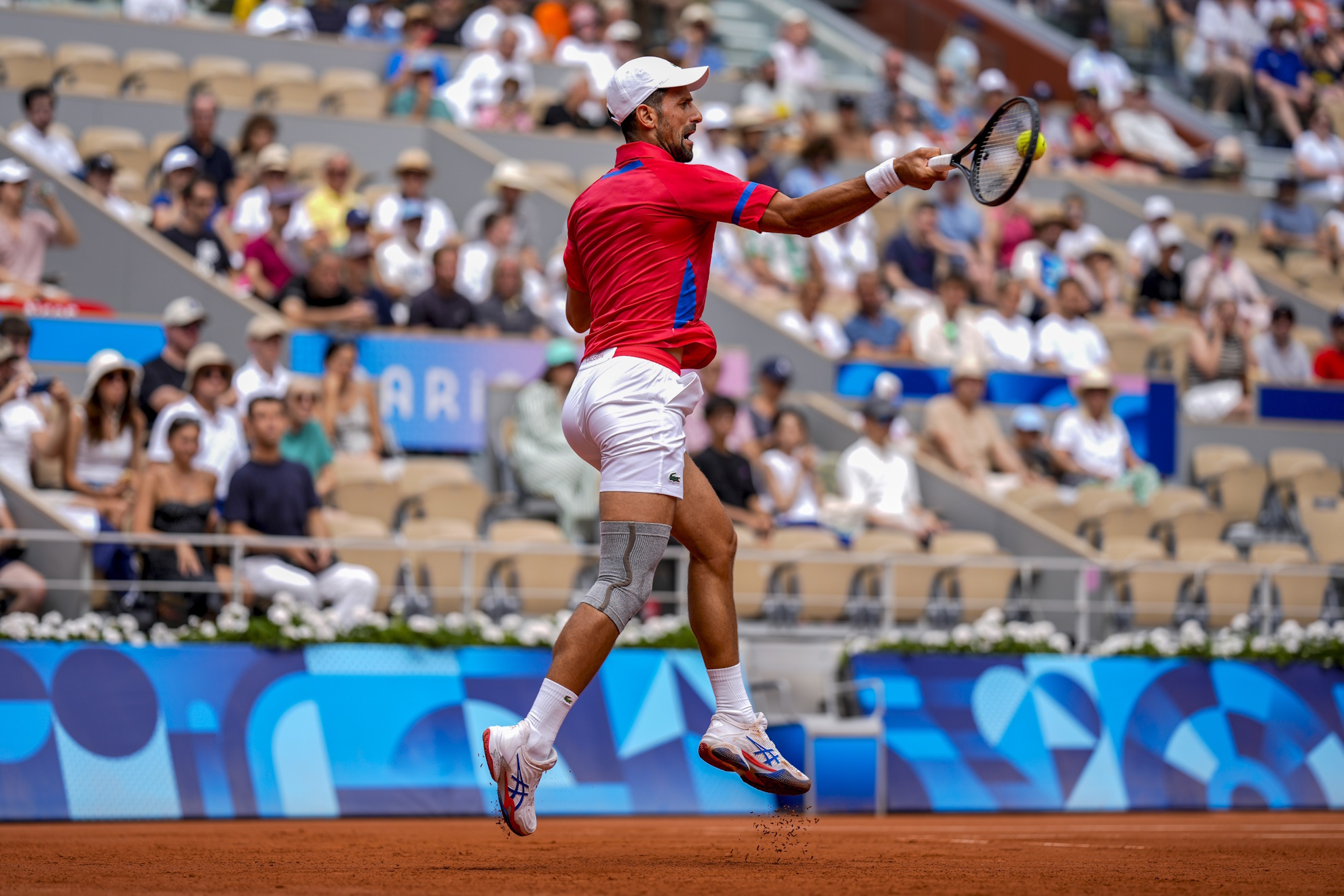 Serbias Novak Djokovic returns the ball against Germanys Dominik Koepfer.