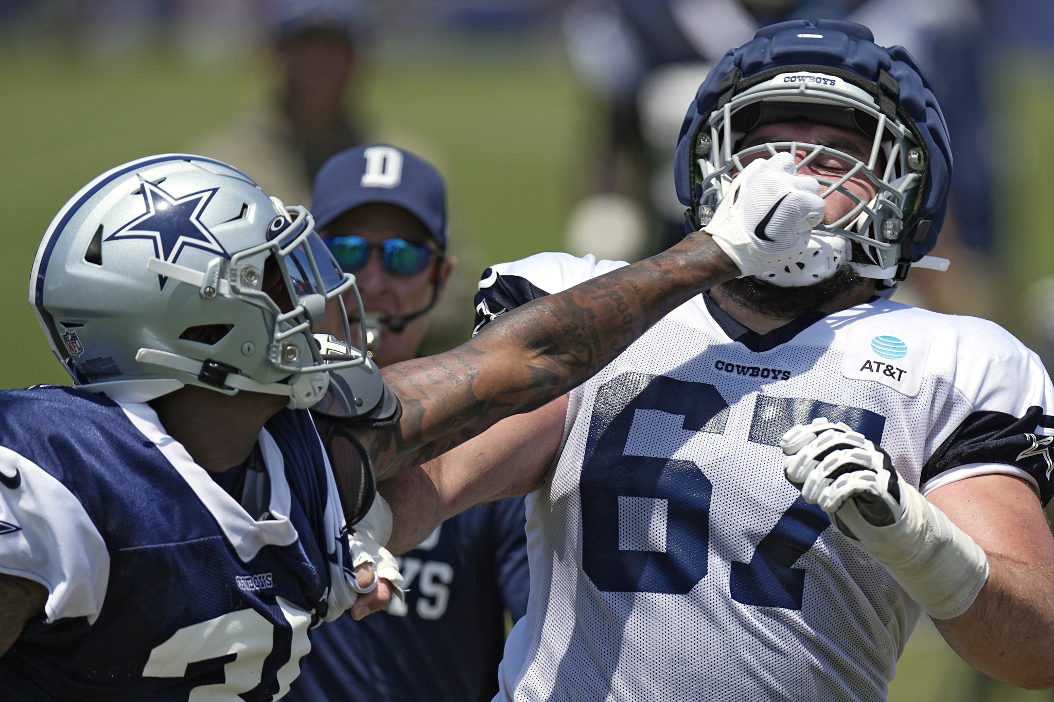 Dallas Cowboys safety Juanyeh Thomas, left, and center Brock Hoffman clash after a play during the NFL football teams training camp