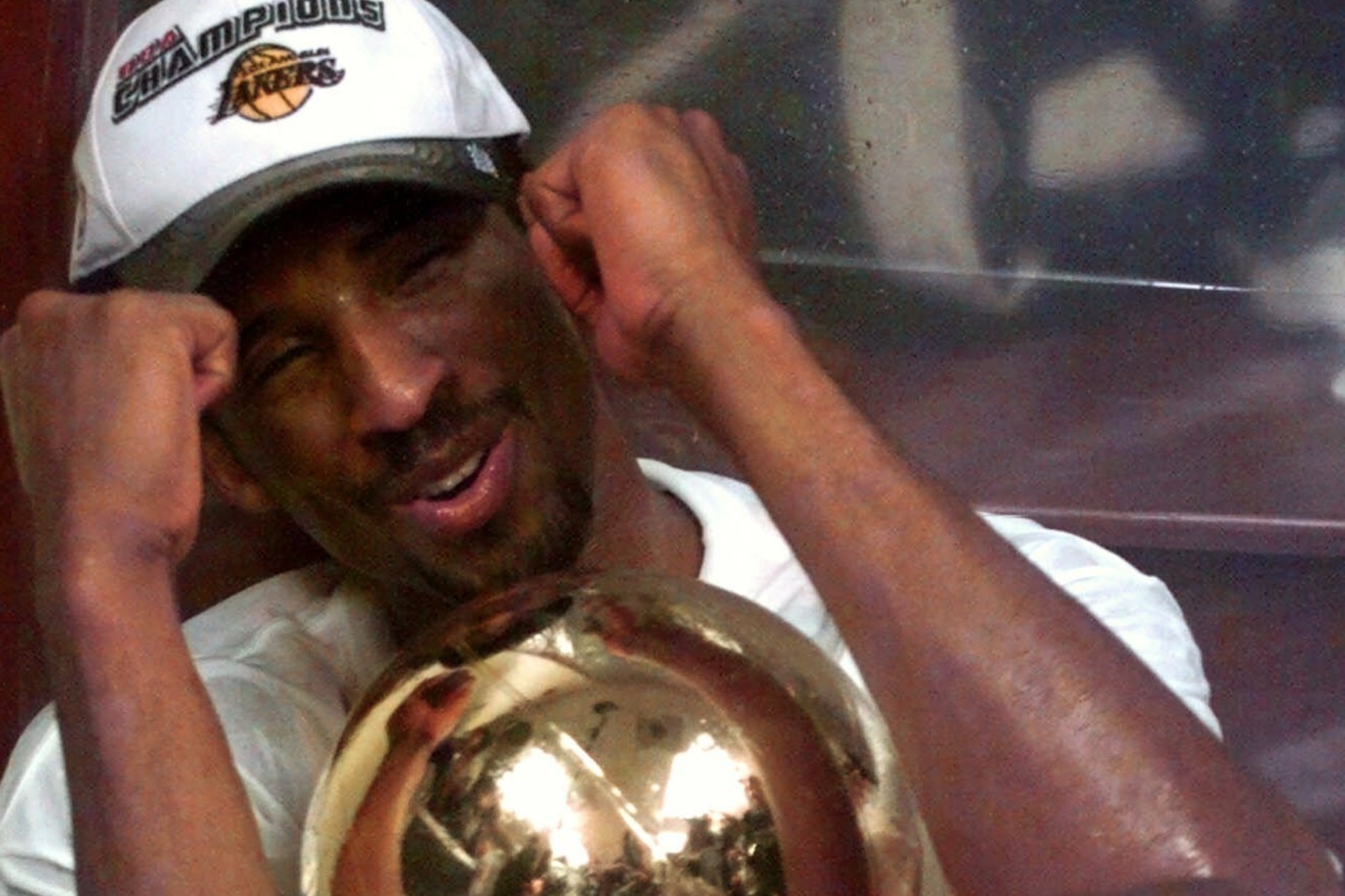 Los Angeles Lakers Kobe Bryant holds onto the NBA Championship trophy in the locker room after the Lakers took the championship from the Indiana Pacers with a 116-111 win in Game 6 of the NBA Finals in Los Angeles Monday, June 19, 2000. (AP Photo/Reed Saxon)