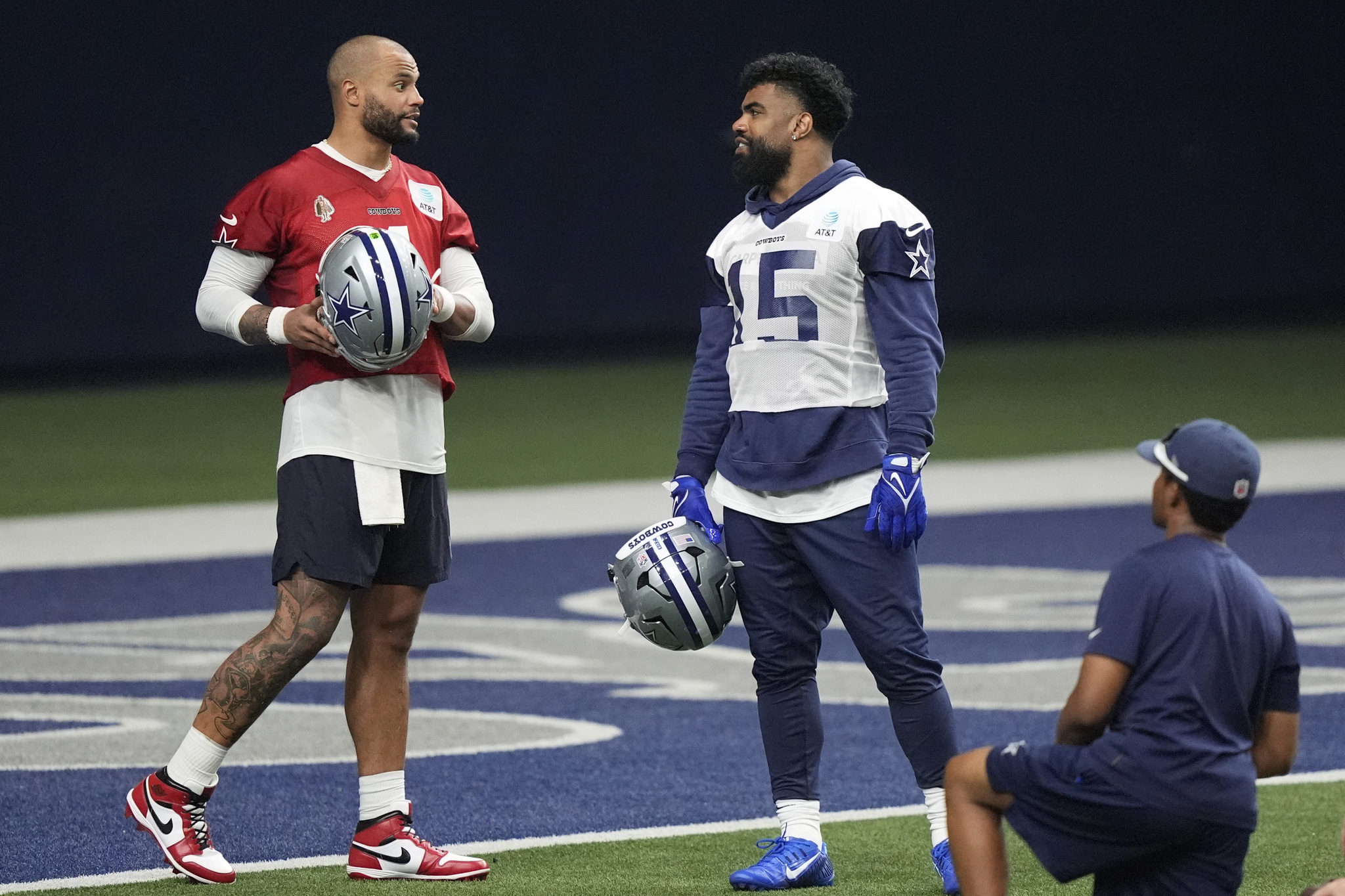 Dallas Cowboys quarterback Dak Prescott, left, talks with teammate running back Ezekiel Elliott