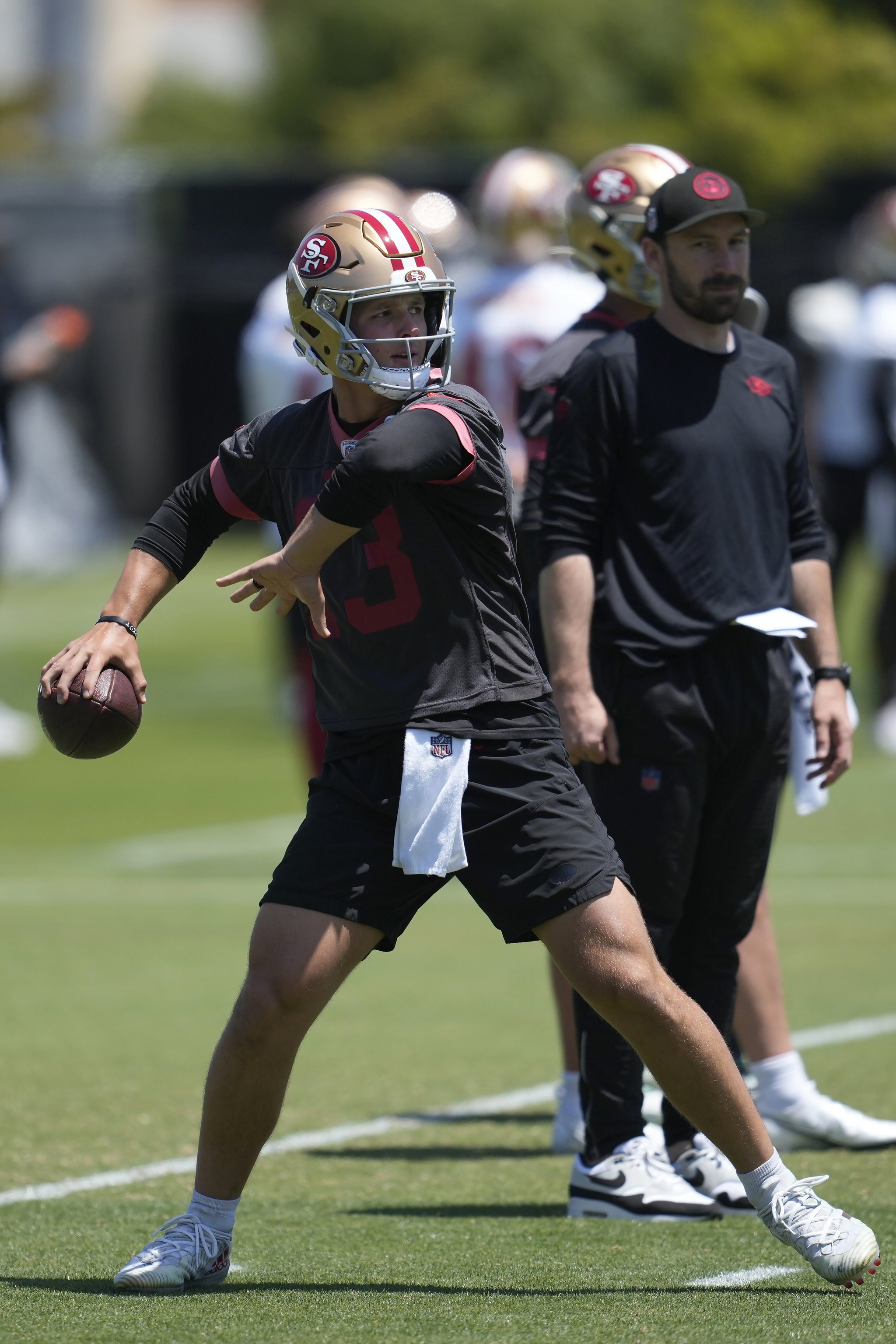 San Francisco 49ers quarterback Brock Purdy, left, throws a pass in front of assistant quarterbacks coach Klay Kubiak